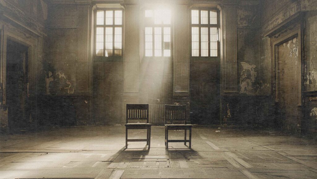 Leerer Gerichtssaal mit Holzstühlen, Sonnenlicht fällt durch die Fenster auf den Boden – Symbolbild für die Debatte Täterschutz vs. Opferschutz.